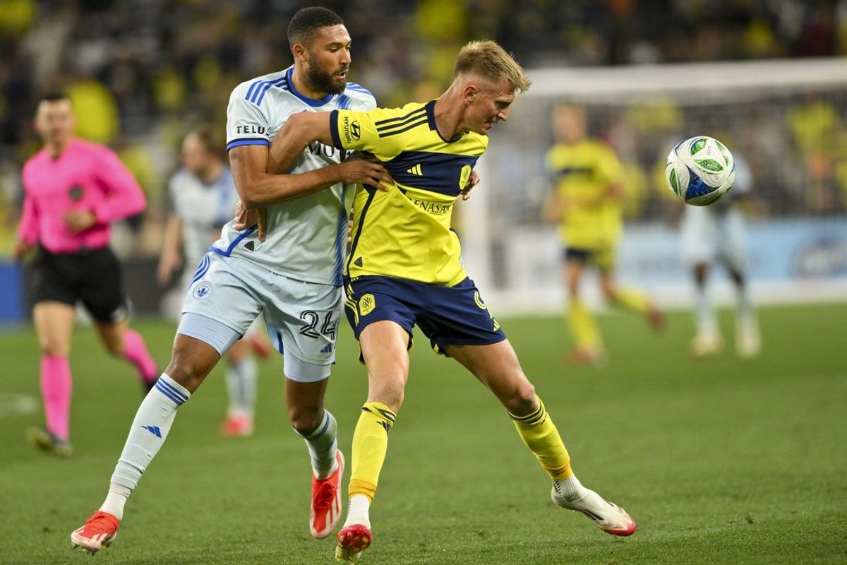 Mar 22, 2025; Nashville, Tennessee, USA;  CF Montreal defender George Campbell (24) and Nashville SC forward Sam Surridge (9) fights for the ball during the second half at Geodis Park. Mandatory Credit: Steve Roberts-Imagn Images