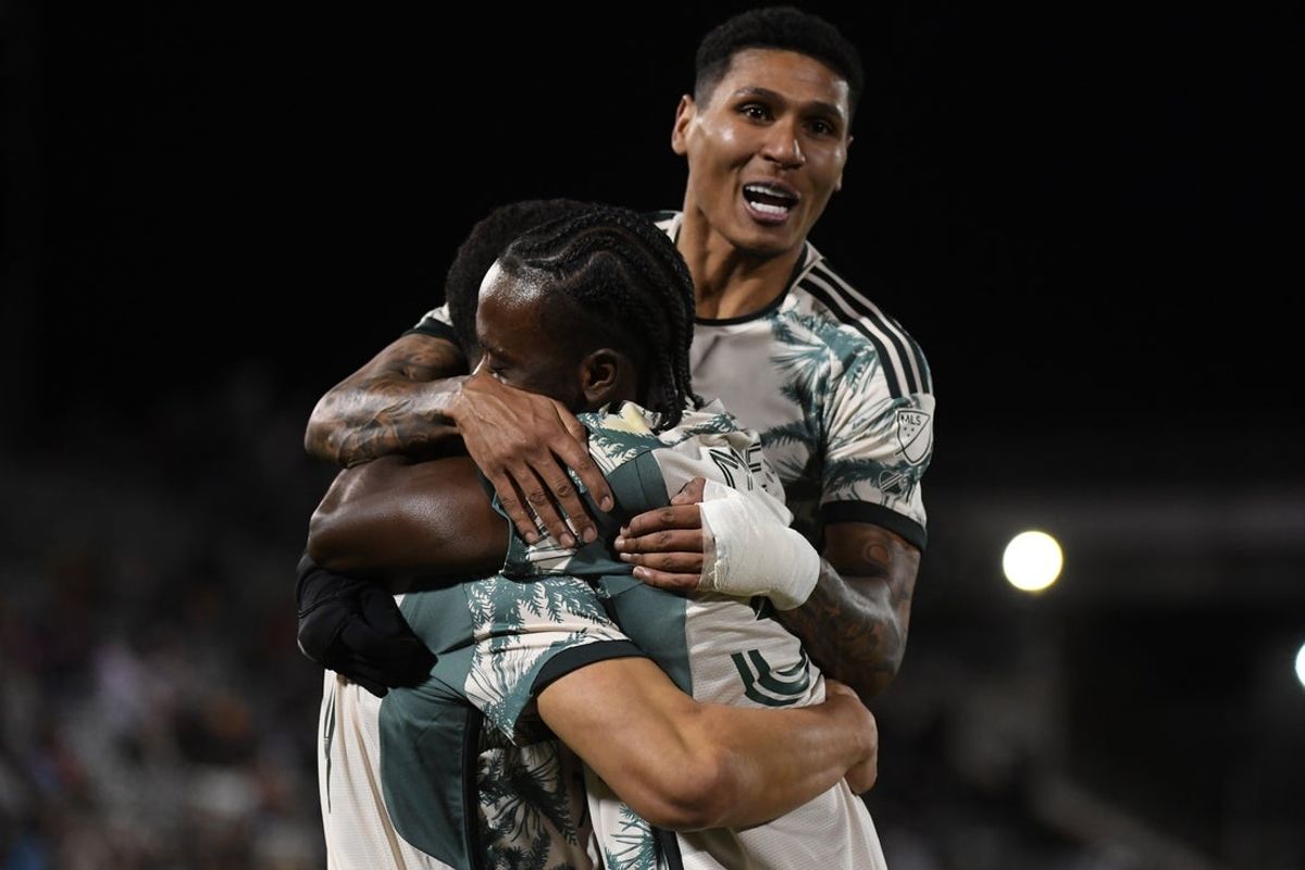 Mar 22, 2025; Commerce City, Colorado, USA; Portland Timbers forward Kevin Kelsy (19) celebrates with midfielder Santiago Moreno (30) and forward Antony (11) after a goal during the second half against the Colorado Rapids at Dick's Sporting Goods Park. Mandatory Credit: Christopher Hanewinckel-Imagn Images