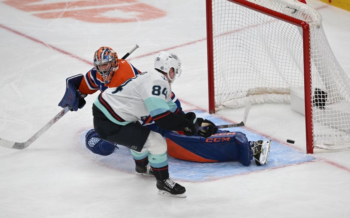 Mar 22, 2025; Edmonton, Alberta, CAN;  Edmonton Oilers goalie Stuart Skinner (74) battles for the puck with Seattle Kraken right wing Kappo Kakko (84) during the second period at Rogers Place. Mandatory Credit: Walter Tychnowicz-Imagn Images