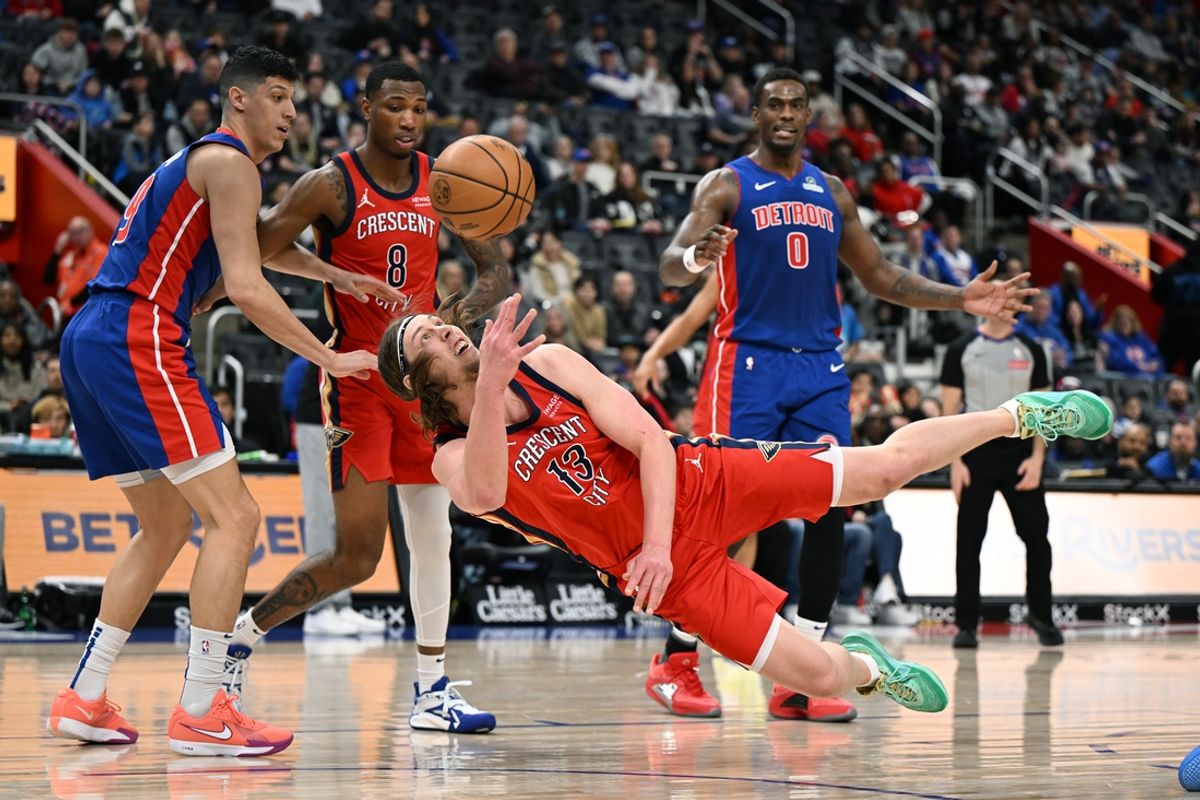 Mar 23, 2025; Detroit, Michigan, USA; New Orleans Pelicans forward Kelly Olynyk (13) shoots the ball while falling to the court after tripping over Detroit Pistons forward Tobias Harris (12) in the first quarter at Little Caesars Arena. Mandatory Credit: Lon Horwedel-Imagn Images