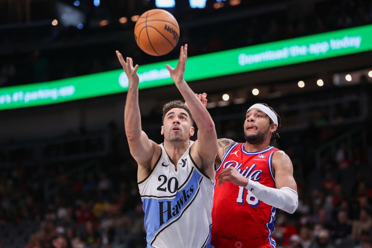 Mar 23, 2025; Atlanta, Georgia, USA; Atlanta Hawks forward Georges Niang (20) grabs a rebound past Philadelphia 76ers forward Chuma Okeke (18) in the first quarter at State Farm Arena. Mandatory Credit: Brett Davis-Imagn Images
