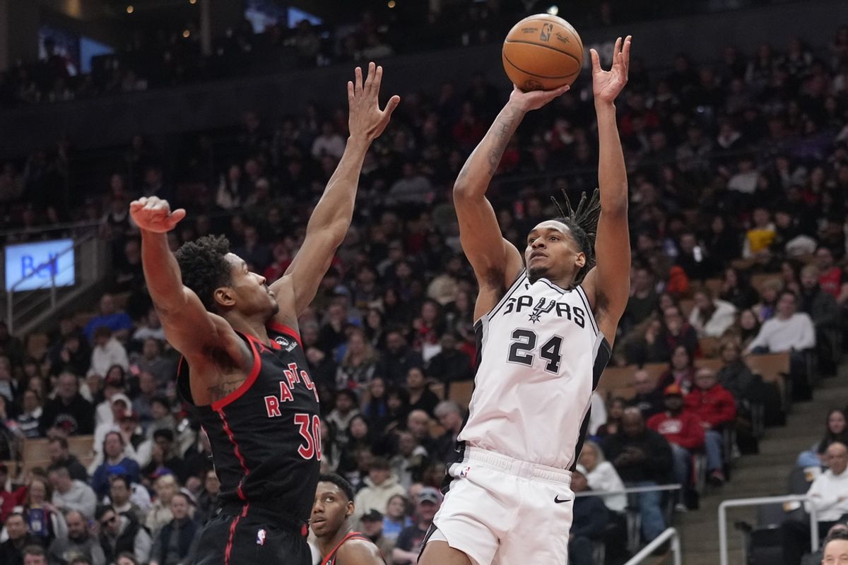 Mar 23, 2025; Toronto, Ontario, CAN; San Antonio Spurs guard Devin Vassell (24) goes up to shoot a basket against Toronto Raptors forward Ochai Agbaji (30) during the second half at Scotiabank Arena. Mandatory Credit: John E. Sokolowski-Imagn Images