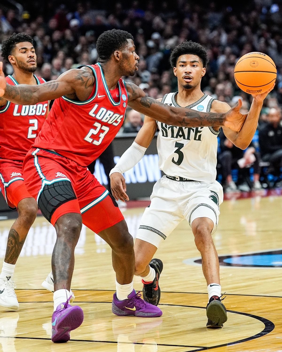 Michigan State guard Jaden Akins (3) pass the ball against New Mexico center Nelly Junior Joseph (23) during the first half of the Second Round of NCAA tournament at Rocket Arena in Cleveland, Ohio on Sunday, March 23, 2025.