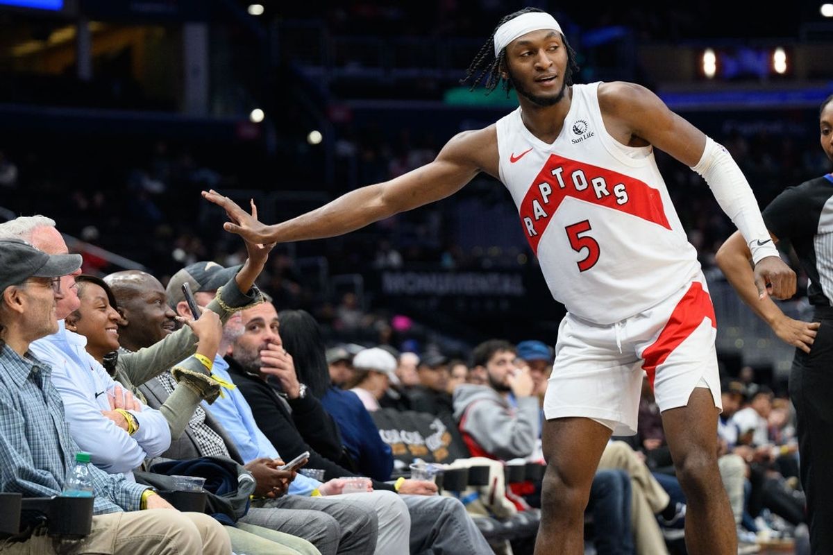 Mar 24, 2025; Washington, District of Columbia, USA; Toronto Raptors guard Immanuel Quickley (5) celebrates with fan during the third quarter against the Washington Wizards at Capital One Arena. Mandatory Credit: Reggie Hildred-Imagn Images