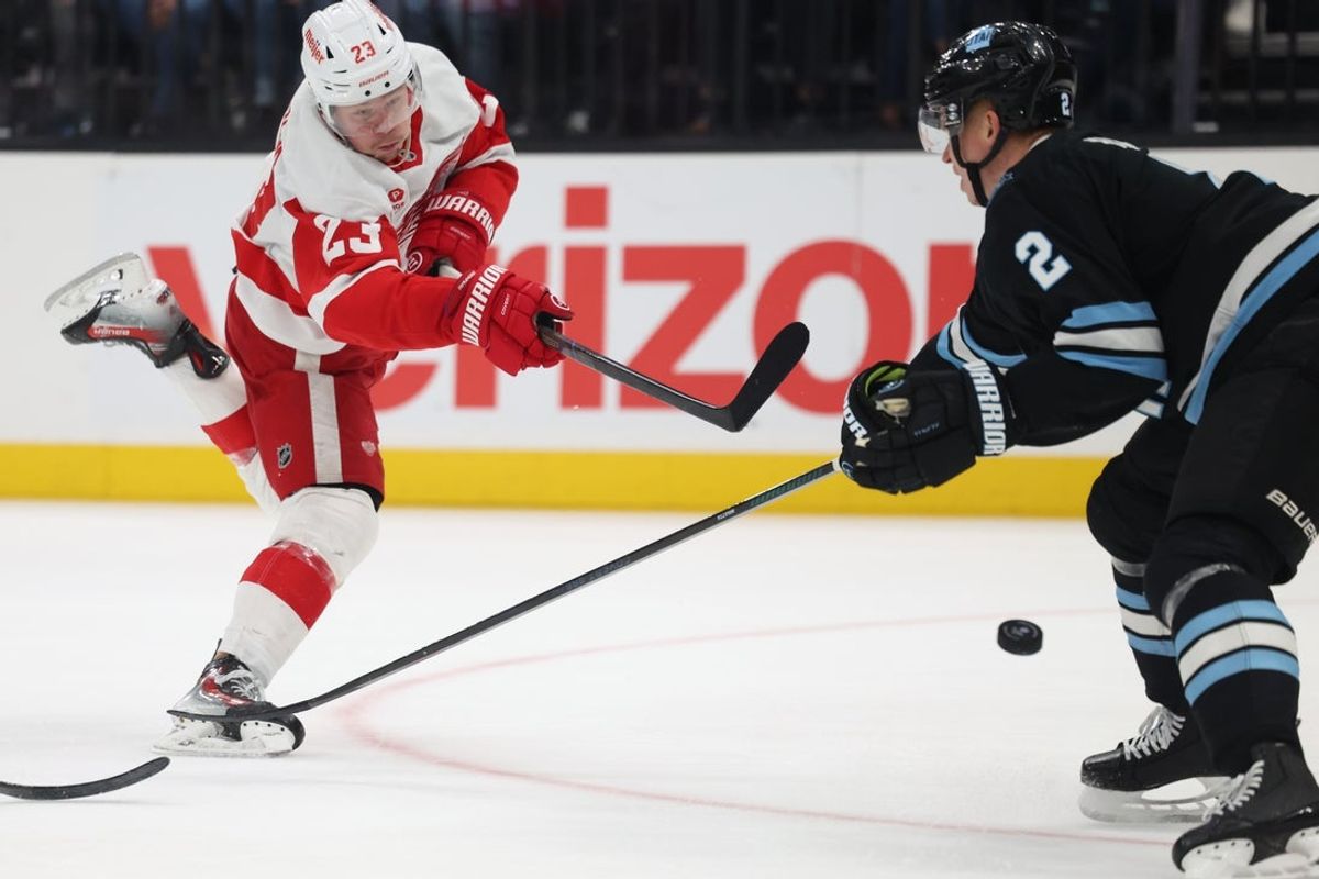 Mar 24, 2025; Salt Lake City, Utah, USA; Detroit Red Wings left wing Lucas Raymond (23) takes a shot as Utah Hockey Club defenseman Olli Määttä (2) defends during the second period at Delta Center. Mandatory Credit: Rob Gray-Imagn Images