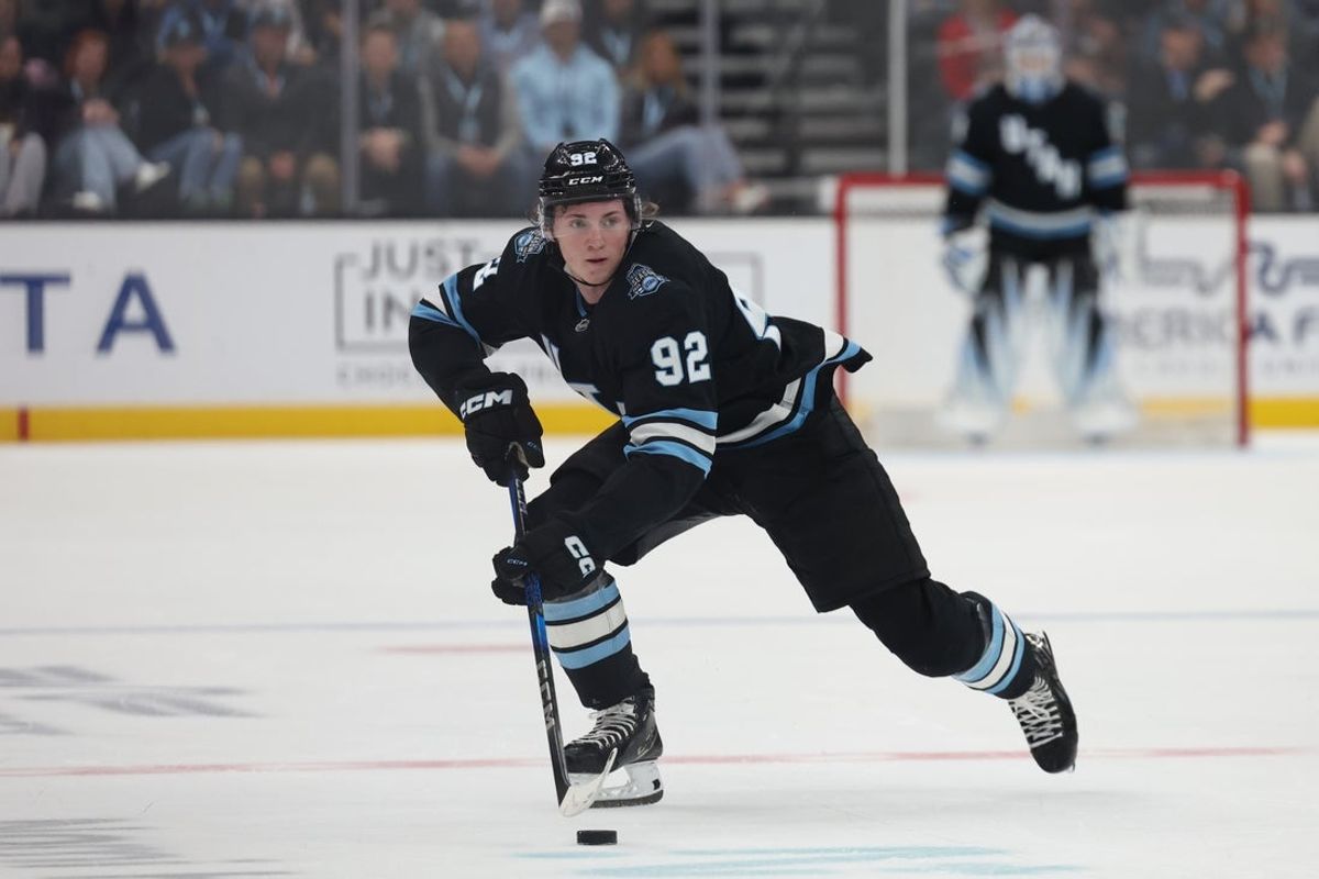 Mar 24, 2025; Salt Lake City, Utah, USA; Utah Hockey Club center Logan Cooley brings the puck up the ice during the third period against the Detroit Red Wings at Delta Center. Mandatory Credit: Rob Gray-Imagn Images