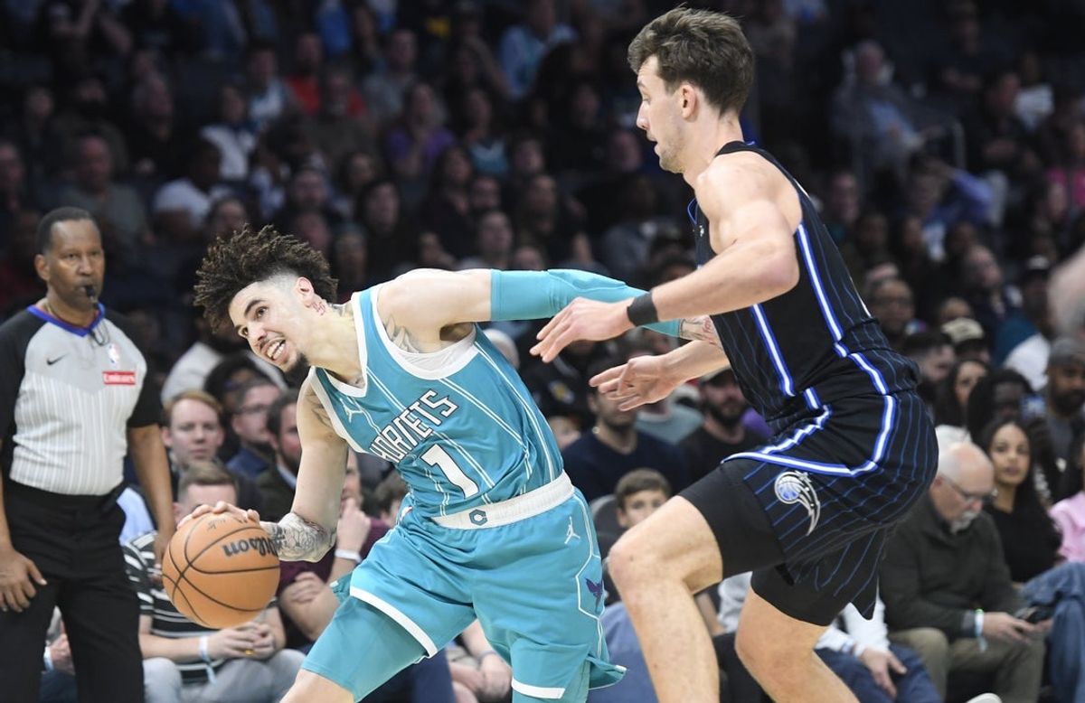Mar 25, 2025; Charlotte, North Carolina, USA;  Charlotte Hornets guard LaMelo Ball (1) drives past Orlando Magic forward Franz Wagner (22) during the second half at the Spectrum Center. Mandatory Credit: Sam Sharpe-Imagn Images