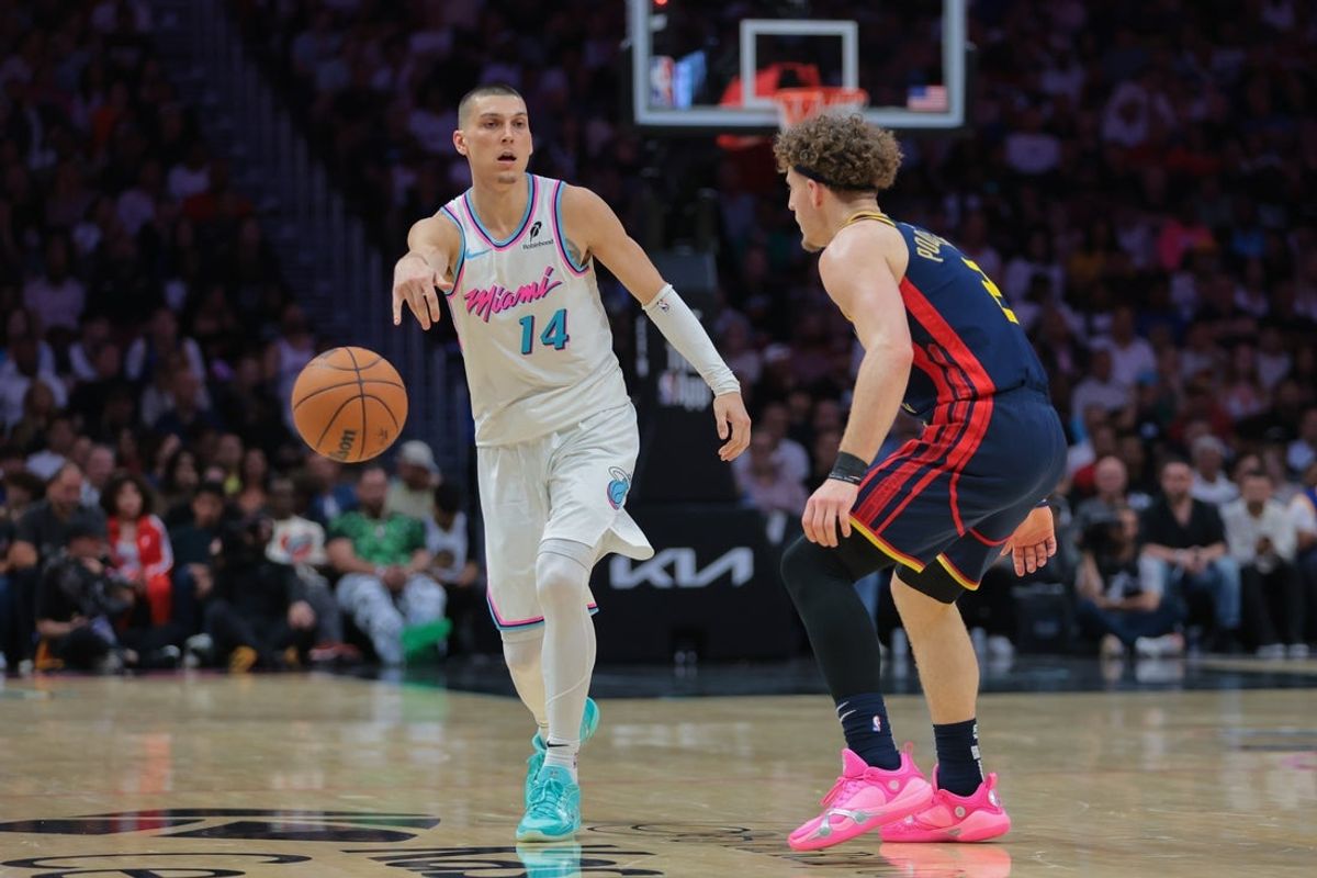 Mar 25, 2025; Miami, Florida, USA; Miami Heat guard Tyler Herro (14) passes the basketball as Golden State Warriors guard Brandin Podziemski (2) defends during the third quarter at Kaseya Center. Mandatory Credit: Sam Navarro-Imagn Images