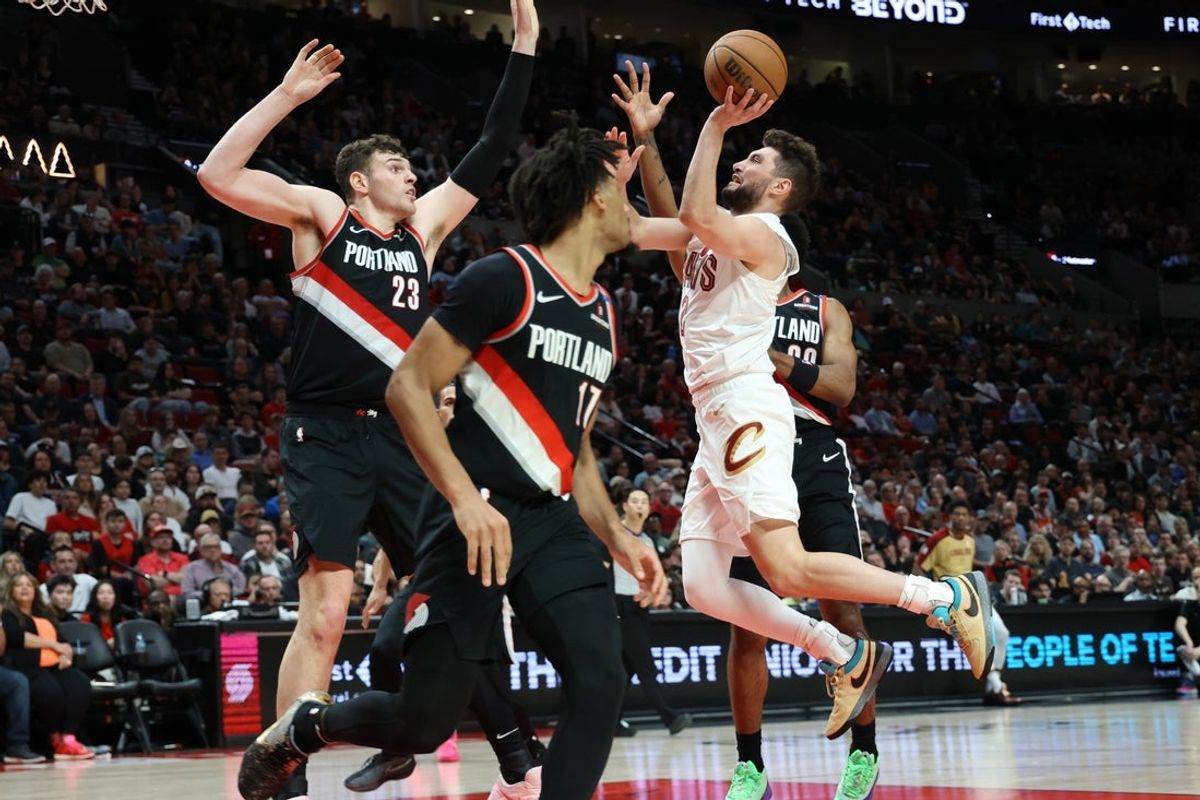 Mar 25, 2025; Portland, Oregon, USA;  Cleveland Cavaliers guard Ty Jerome (2) shoots the ball over Portland Trail Blazers center Donovan Clingan (23) and guard Shaedon Sharpe (17) in the first half at Moda Center. Mandatory Credit: Jaime Valdez-Imagn Images