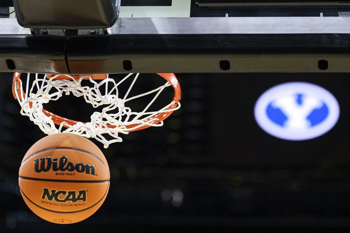 Mar 26, 2025; Newark, NJ, USA; An NCAA Wilson official game ball passes thorough a basket in front of an Brigham Young Cougars logo during a practice sessions in preparation for an East Regional semifinal games at Prudential Center. Mandatory Credit: Vincent Carchietta-Imagn Images