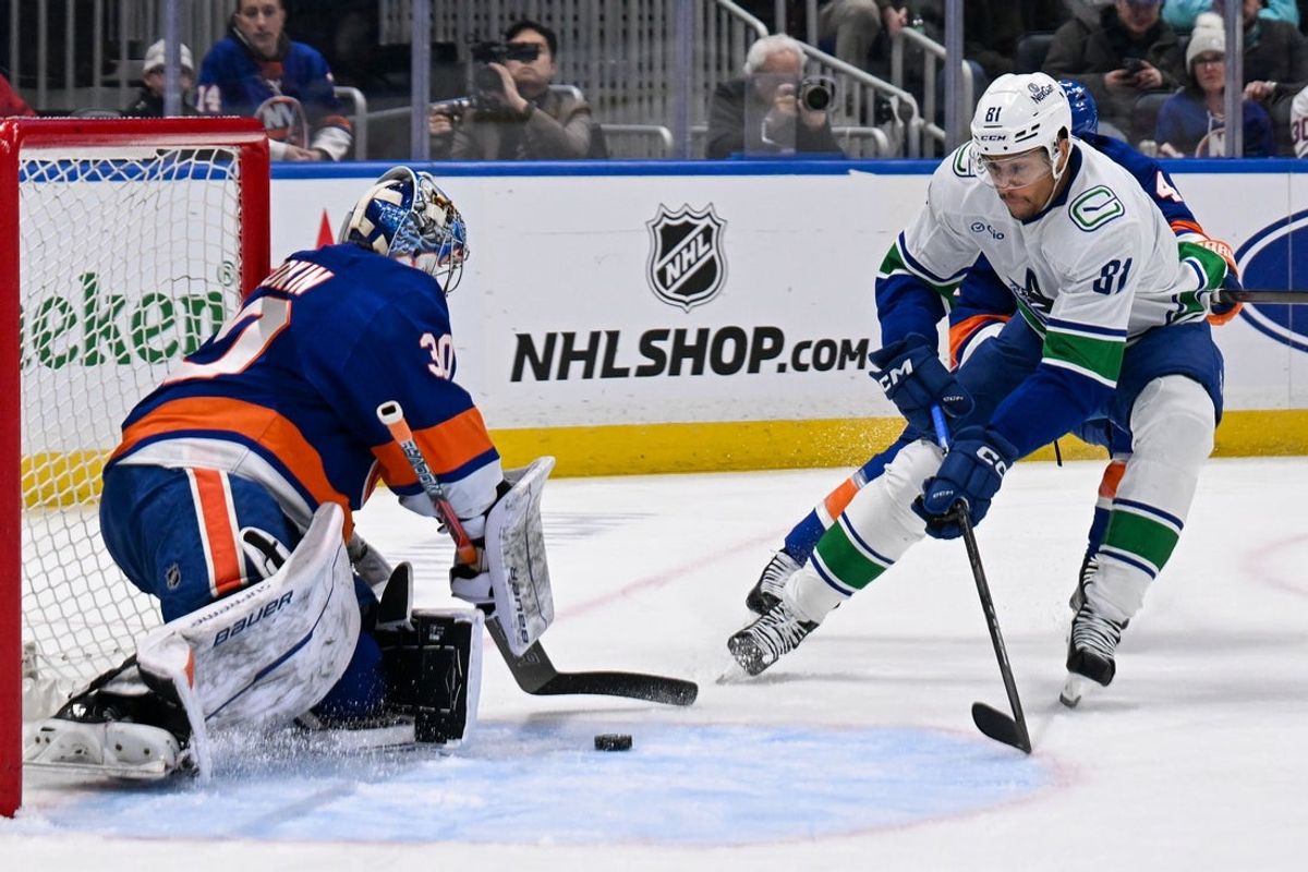 Mar 26, 2025; Elmont, New York, USA; New York Islanders goaltender Ilya Sorokin (30) makes a save on Vancouver Canucks center Dakota Joshua (81) during the first period  at UBS Arena. Mandatory Credit: Dennis Schneidler-Imagn Images