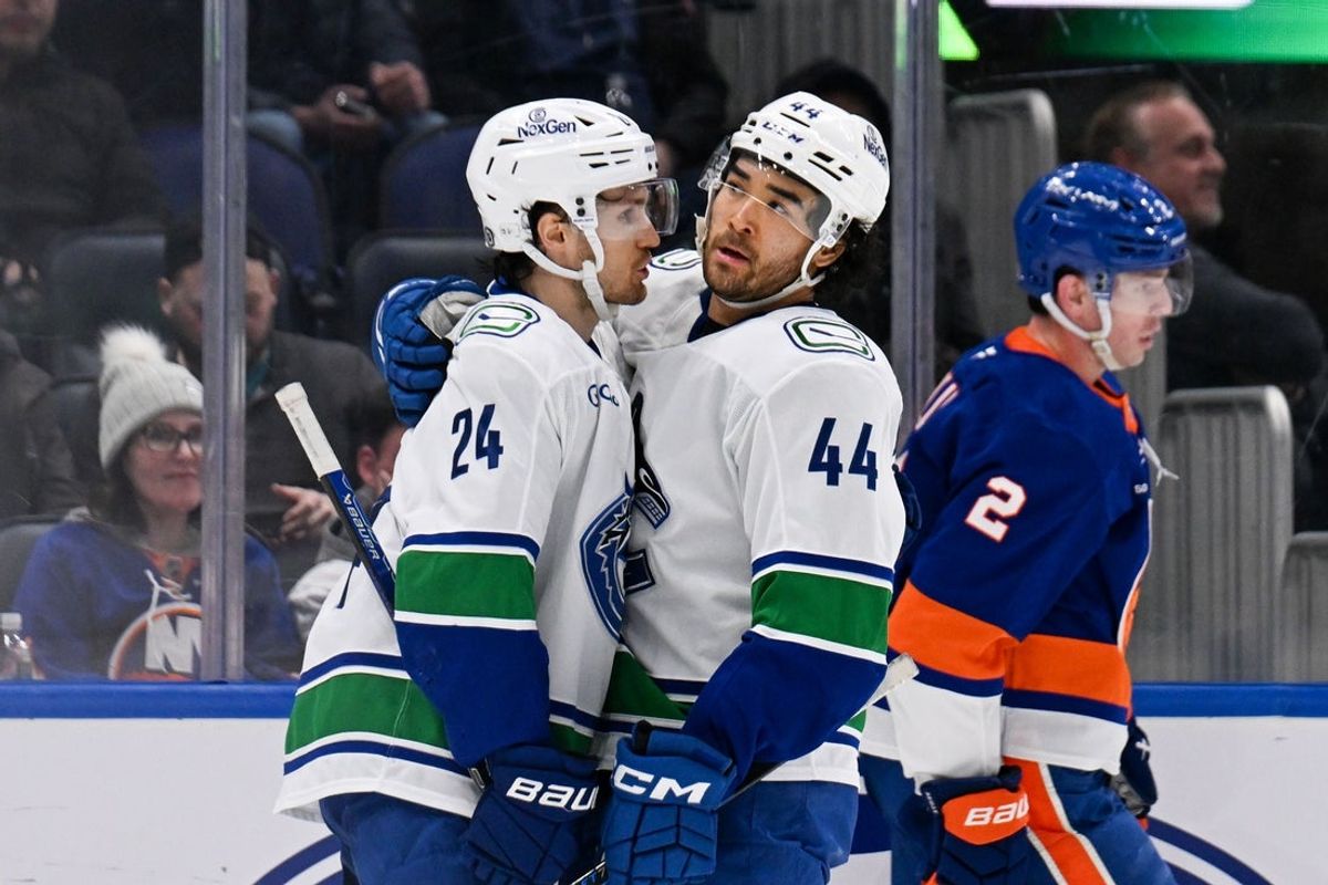 Mar 26, 2025; Elmont, New York, USA;  Vancouver Canucks left wing Kiefer Sherwood (44) celebrates his empty net goal against the New York Islanders with center Pius Suter (24) during the third period at UBS Arena. Mandatory Credit: Dennis Schneidler-Imagn Images