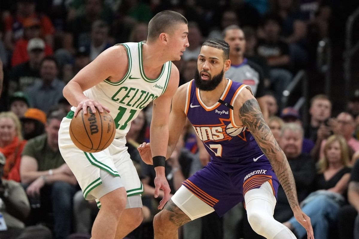 Mar 26, 2025; Phoenix, Arizona, USA; Boston Celtics guard Payton Pritchard (11) drives on Phoenix Suns forward Cody Martin (17) during the first half at Footprint Center. Mandatory Credit: Rick Scuteri-Imagn Images