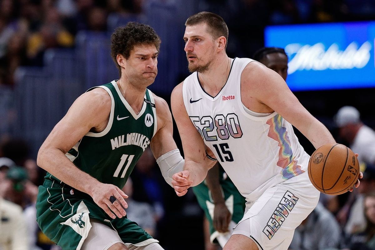 Mar 26, 2025; Denver, Colorado, USA; Denver Nuggets center Nikola Jokic (15) controls the ball as Milwaukee Bucks center Brook Lopez (11) guards in the fourth quarter at Ball Arena. Mandatory Credit: Isaiah J. Downing-Imagn Images