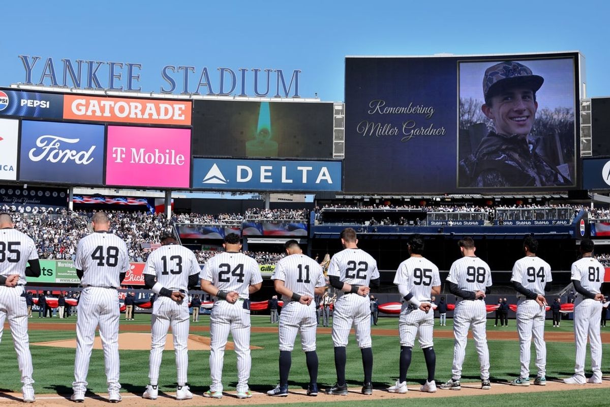 Mar 27, 2025; Bronx, New York, USA; New York Yankees players stand for a moment of silence to honor the memory of Miller Gardner son of Yankees former player Brett Gardner (not pictured) before an opening day game against the Milwaukee Brewers at Yankee Stadium. Mandatory Credit: Brad Penner-Imagn Images