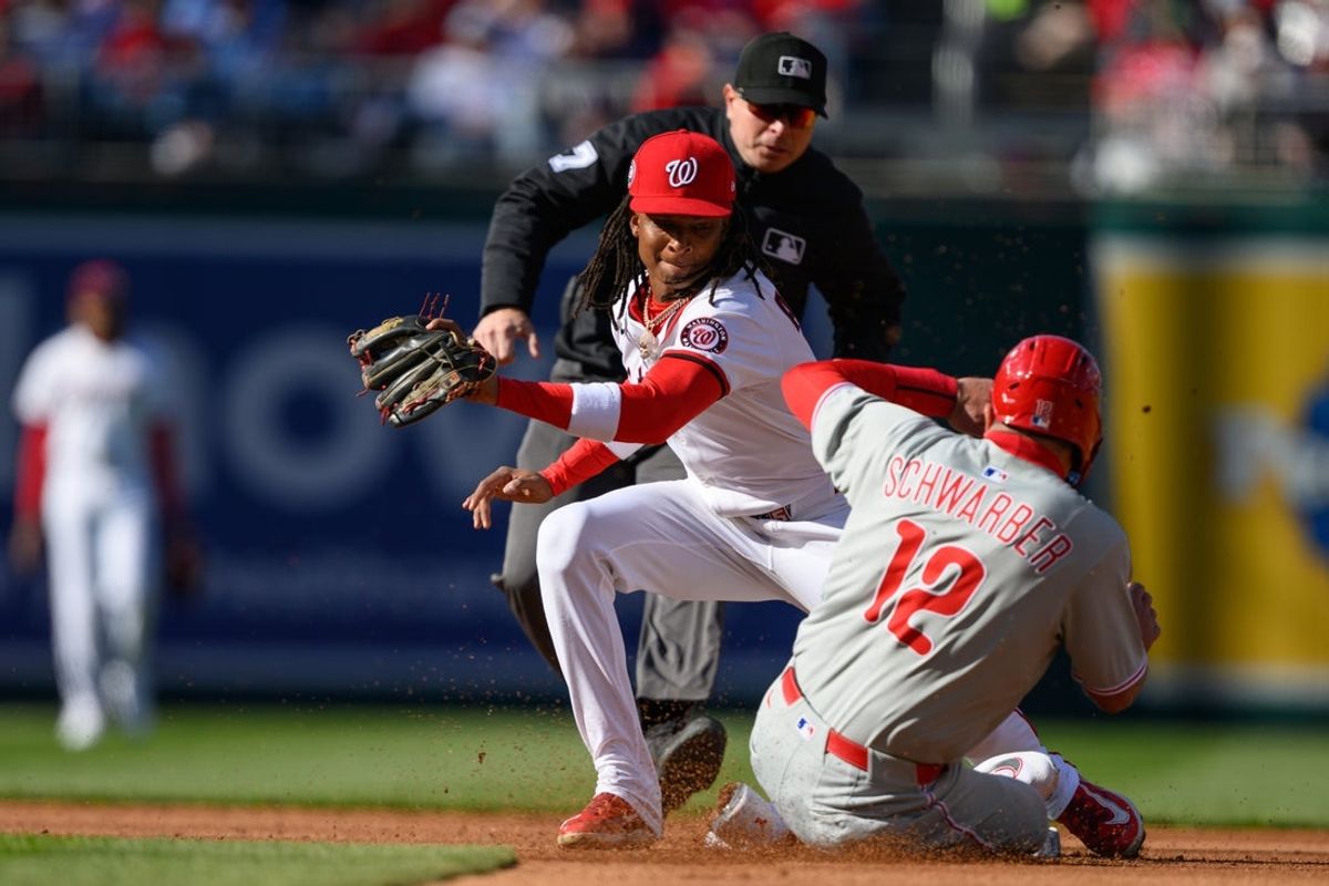 Mar 27, 2025; Washington, District of Columbia, USA; Washington Nationals shortstop CJ Abrams (5) tags Philadelphia Phillies designated hitter Kyle Schwarber (12) out at second base during the second inning at Nationals Park. Mandatory Credit: Reggie Hildred-Imagn Images