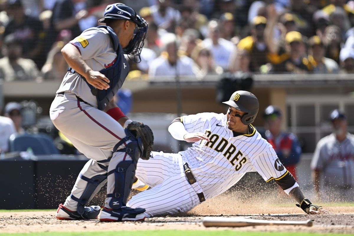 Mar 27, 2025; San Diego, California, USA; San Diego Padres third baseman Manny Machado (13) scores ahead of the throw to Atlanta Braves catcher Drake Baldwin (30) during the first inning of a baseball game at Petco Park. Mandatory Credit: Denis Poroy-Imagn Images