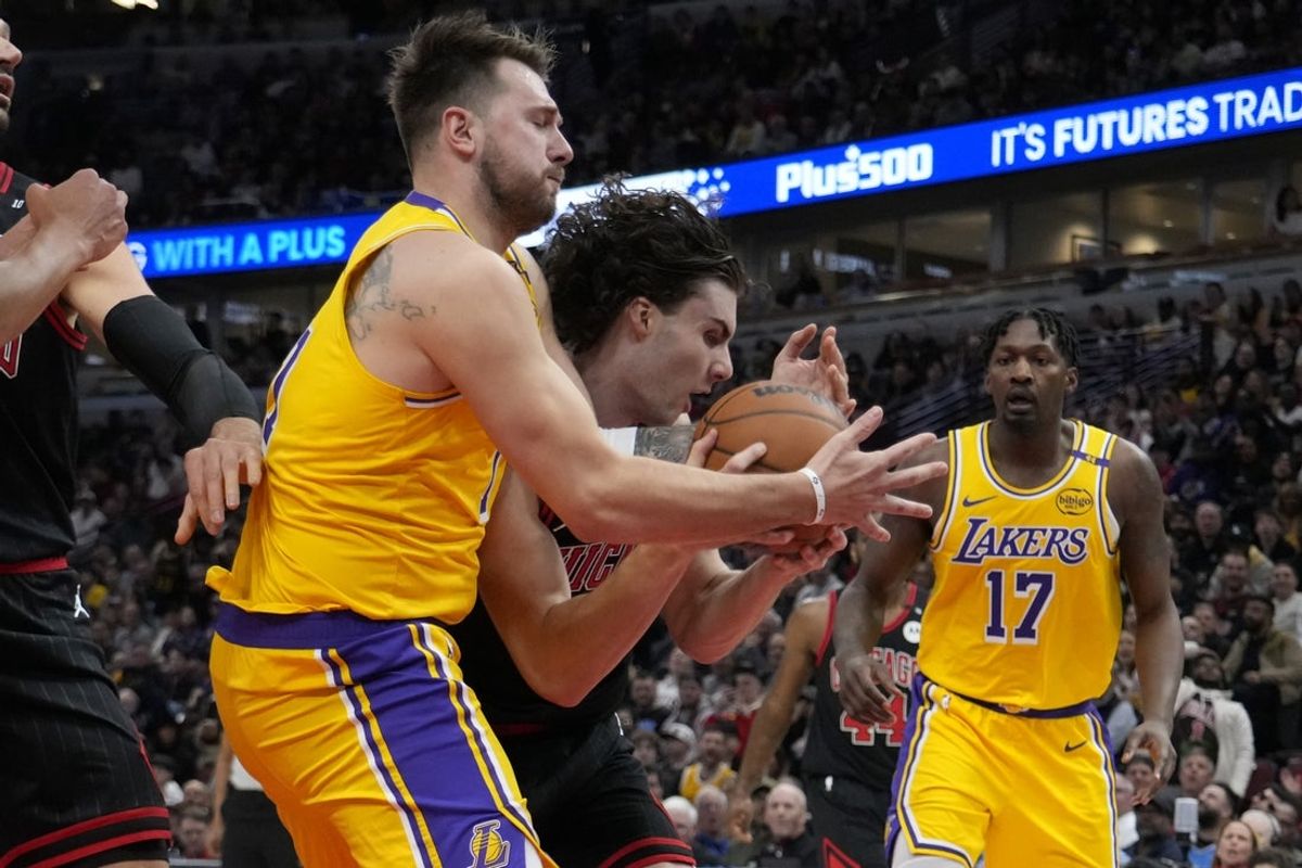 Mar 27, 2025; Chicago, Illinois, USA; Los Angeles Lakers guard Luka Doncic (77) defends Chicago Bulls guard Josh Giddey (3) during the first quarter  at United Center. Mandatory Credit: David Banks-Imagn Images