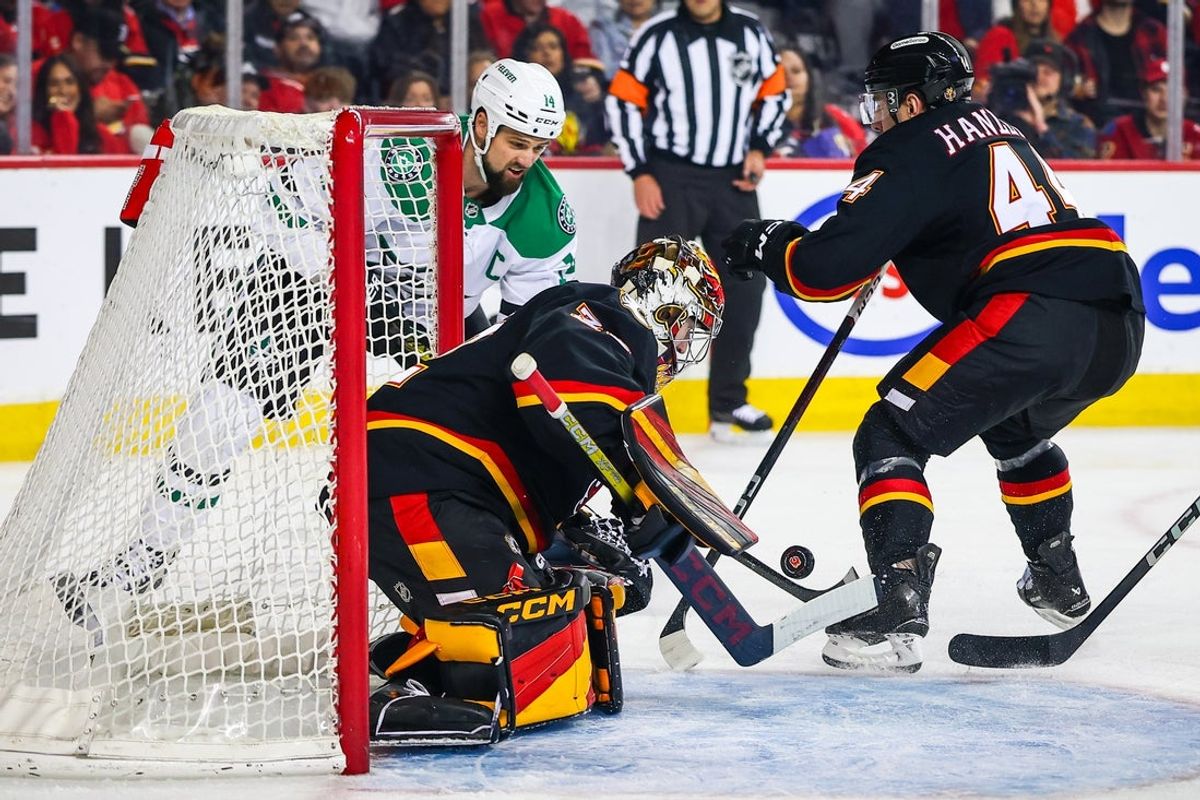 Mar 27, 2025; Calgary, Alberta, CAN; Calgary Flames goaltender Dustin Wolf (32) makes a save against Dallas Stars left wing Jamie Benn (14) during the first period at Scotiabank Saddledome. Mandatory Credit: Sergei Belski-Imagn Images