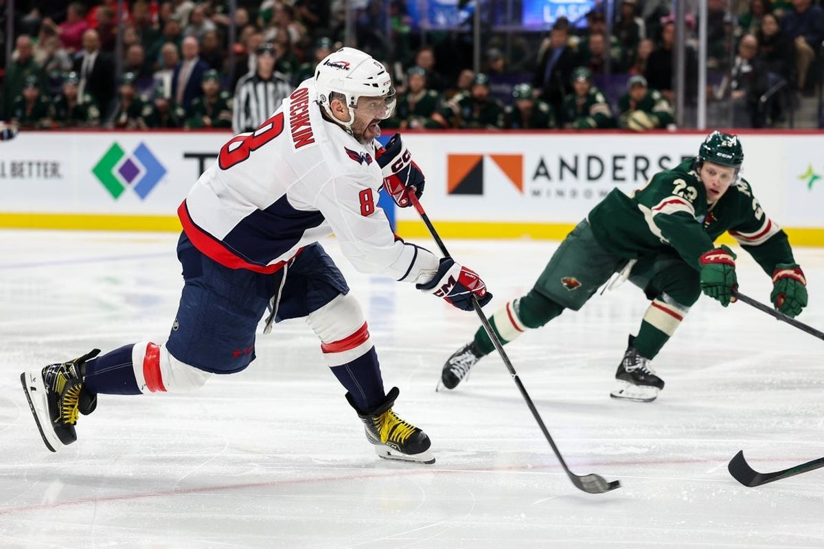 Mar 27, 2025; Saint Paul, Minnesota, USA; Washington Capitals left wing Alex Ovechkin (8) shoots the puck as Minnesota Wild center Marco Rossi (23) defends during the third period at Xcel Energy Center. Mandatory Credit: Matt Krohn-Imagn Images