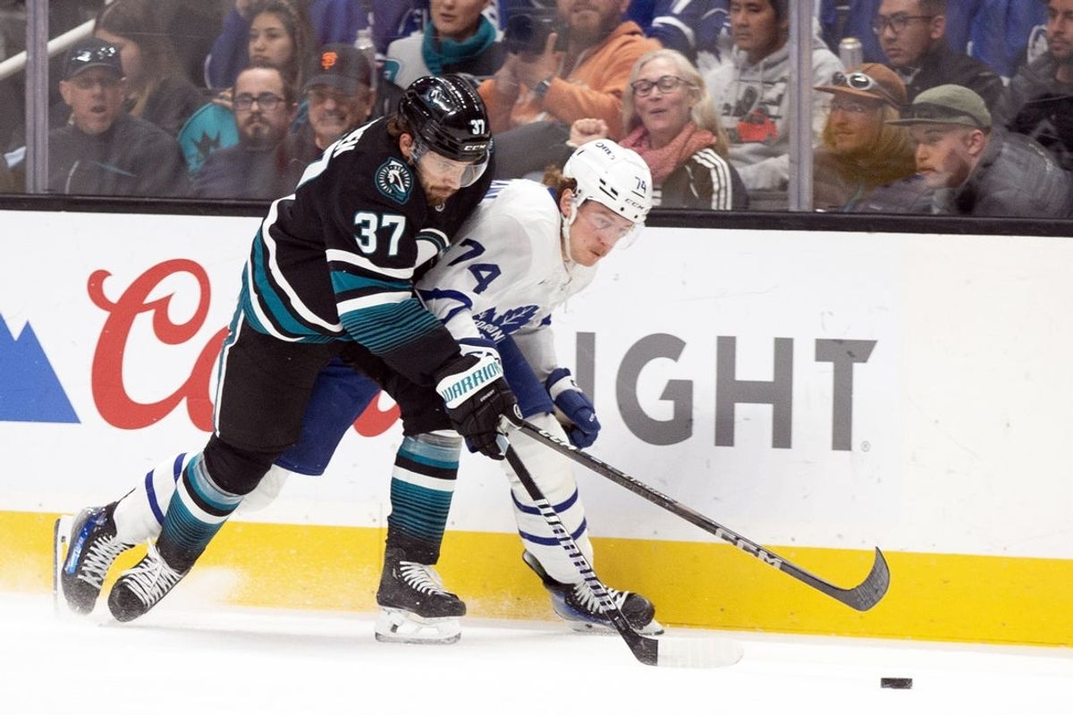Mar 27, 2025; San Jose, California, USA; San Jose Sharks defenseman Timothy Liljegren (37) and Toronto Maple Leafs center Bobby McMann (74) battle for the puck during the first period at SAP Center at San Jose. Mandatory Credit: D. Ross Cameron-Imagn Images
