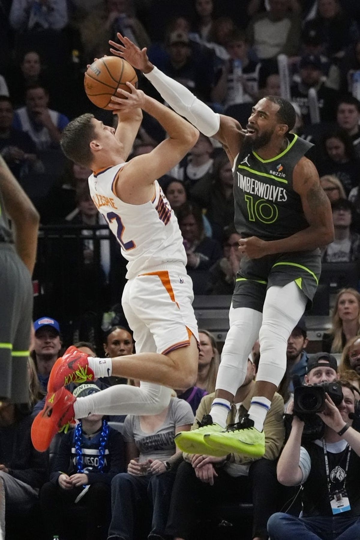 Mar 28, 2025; Minneapolis, Minnesota, USA; Phoenix Suns guard Collin Gillespie (12) shoots against Minnesota Timberwolves guard Mike Conley (10) in the first quarter at Target Center. Mandatory Credit: Bruce Kluckhohn-Imagn Images