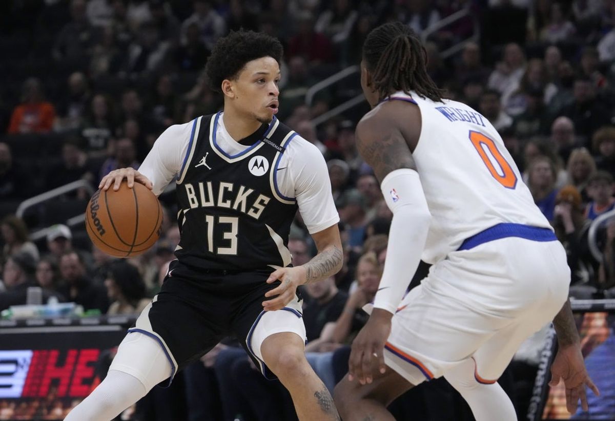 Mar 28, 2025; Milwaukee, Wisconsin, USA;  Milwaukee Bucks guard Ryan Rollins (13) drives against New York Knicks guard Delon Wright (0) in the first half at Fiserv Forum. Mandatory Credit: Michael McLoone-Imagn Images