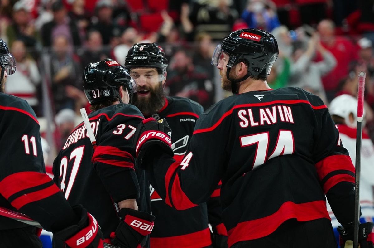 Mar 28, 2025; Raleigh, North Carolina, USA;  Carolina Hurricanes right wing Andrei Svechnikov (37) is congratulated after his empty net goal by defenseman Brent Burns (8) and defenseman Jaccob Slavin (74) against the Montreal Canadiens during the third period at Lenovo Center. Mandatory Credit: James Guillory-Imagn Images