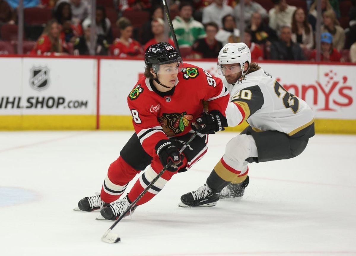 Mar 28, 2025; Chicago, Illinois, USA; Chicago Blackhawks center Connor Bedard (98) and Vegas Golden Knights left wing Brandon Saad (20) battle for control of the puck during the second period at United Center. Mandatory Credit: Talia Sprague-Imagn Images