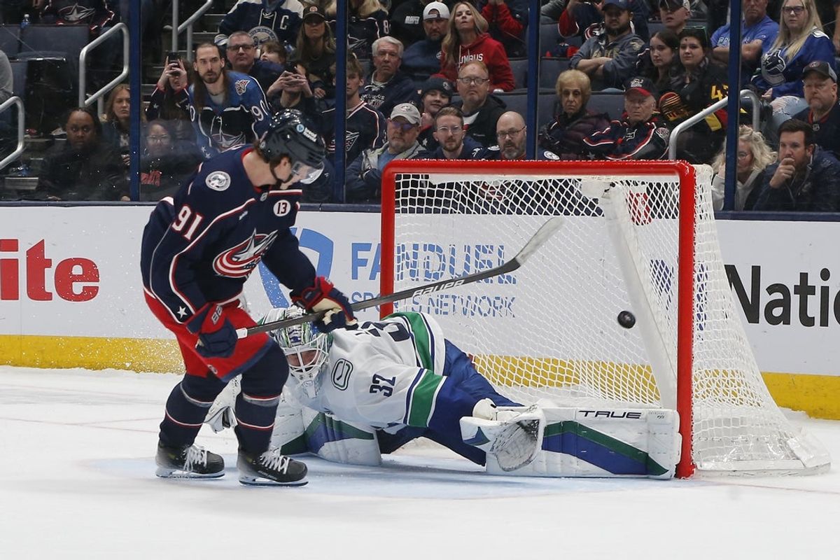 Mar 28, 2025; Columbus, Ohio, USA; Columbus Blue Jackets center Kent Johnson (91) scores a goal on Vancouver Canucks goalie Kevin Lankinen (32) during the shootout at Nationwide Arena. Mandatory Credit: Russell LaBounty-Imagn Images