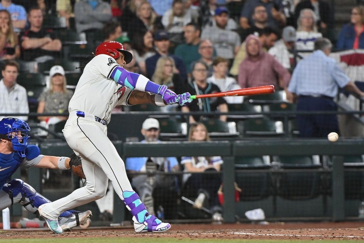 Mar 28, 2025; Phoenix, Arizona, USA;  Arizona Diamondbacks second base Ketel Marte (4) doubles in the seventh inning against the Chicago Cubs at Chase Field. Mandatory Credit: Matt Kartozian-Imagn Images