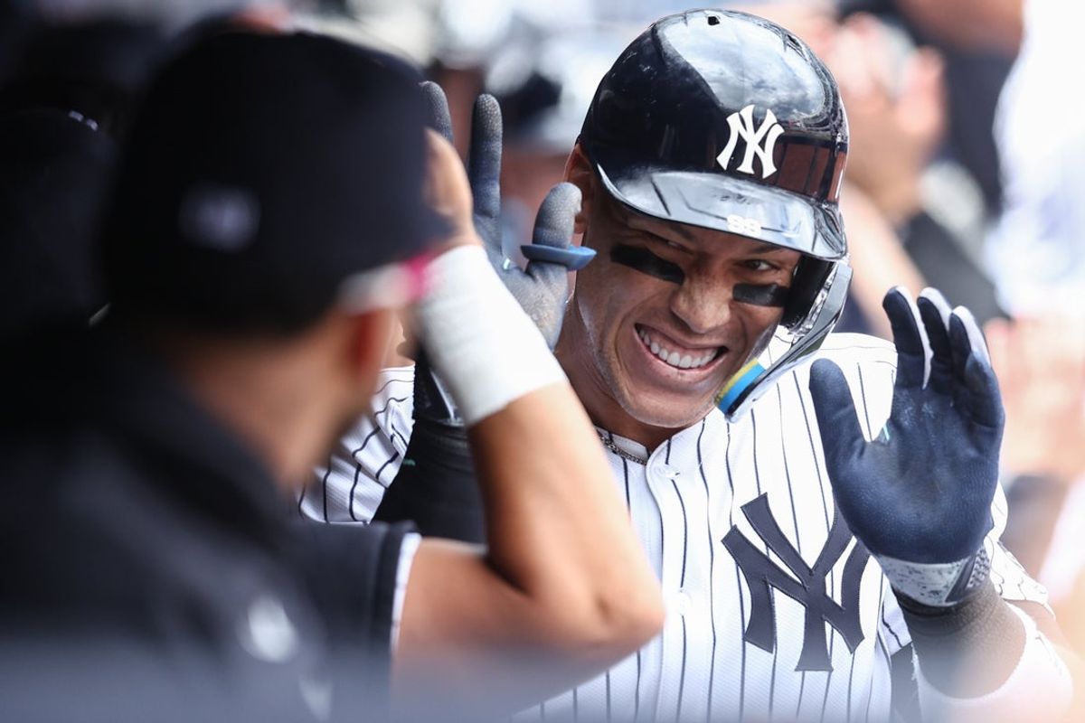 Mar 29, 2025; Bronx, New York, USA; New York Yankees right fielder Aaron Judge (99) celebrates in the dugout after hitting a grand slam home run in the third inning against the Milwaukee Brewers at Yankee Stadium. Mandatory Credit: Wendell Cruz-Imagn Images