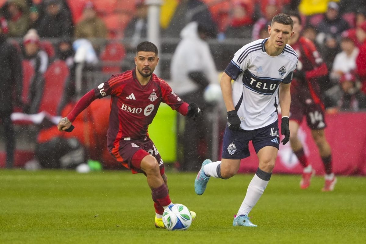 Mar 29, 2025; Toronto, Ontario, CAN; Toronto FC forward Lorenzo Insigne (24) moves the ball against Vancouver Whitecaps defender Ranko Veselinovic (4) during the first half at BMO Field. Mandatory Credit: Kevin Sousa-Imagn Images