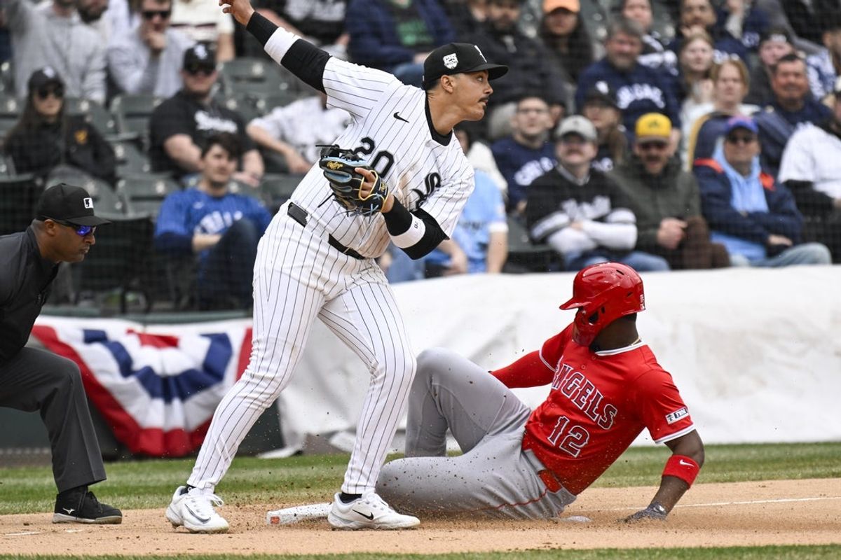 Mar 29, 2025; Chicago, Illinois, USA; Los Angeles Angels outfielder Jorge Soler (12) slides safely into third base under Chicago White Sox third baseman Miguel Vargas (20) during the eighth inning at Guaranteed Rate Field. Mandatory Credit: Matt Marton-Imagn Images