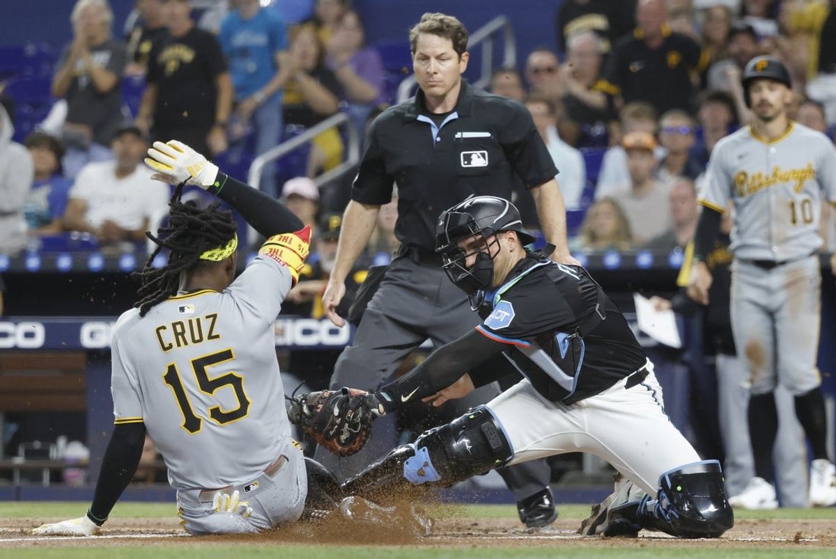 Mar 29, 2025; Miami, Florida, USA;  Miami Marlins catcher Nick Fortes (4) tags Pittsburgh Pirates outfielder Oneil Cruz (15) at the plate during the first inning at loanDepot Park. Mandatory Credit: Rhona Wise-Imagn Images
