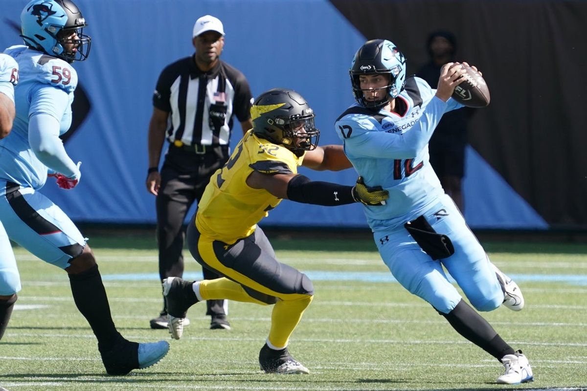 Mar 29, 2025; Arlington, TX, USA; Arlington Renegades quarterback Luis Perez (12) avoids the pressure by San Antonio Brahmas linebacker Kobe Jones  (52) during the first half at Choctaw Stadium. Mandatory Credit: Raymond Carlin III-Imagn Images
