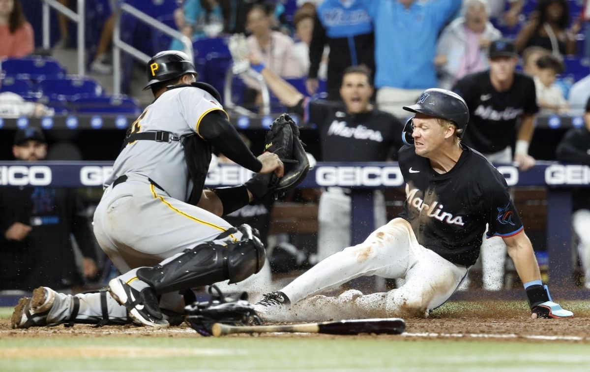 Mar 29, 2025; Miami, Florida, USA;  Miami Marlins left fielder Kyle Stowers (28) is tagged out at the plate by Pittsburgh Pirates catcher Joey Bart (14) during the ninth inning at loanDepot Park. Mandatory Credit: Rhona Wise-Imagn Images