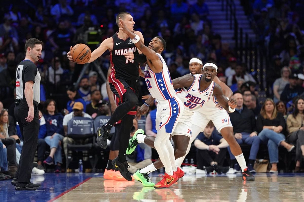 Mar 29, 2025; Philadelphia, Pennsylvania, USA; Miami Heat guard Tyler Herro (14) jumps to pass against Philadelphia 76ers guard Jared Butler (12) in the third quarter at Wells Fargo Center. Mandatory Credit: Kyle Ross-Imagn Images