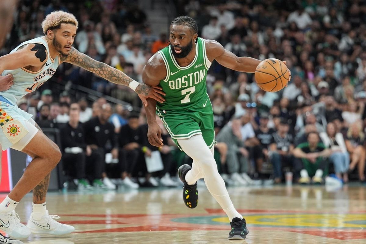 Mar 29, 2025; San Antonio, Texas, USA;  Boston Celtics guard Jaylen Brown (7) dribbles past San Antonio Spurs forward Jeremy Sochan (10) in the second half at Frost Bank Center. Mandatory Credit: Daniel Dunn-Imagn Images