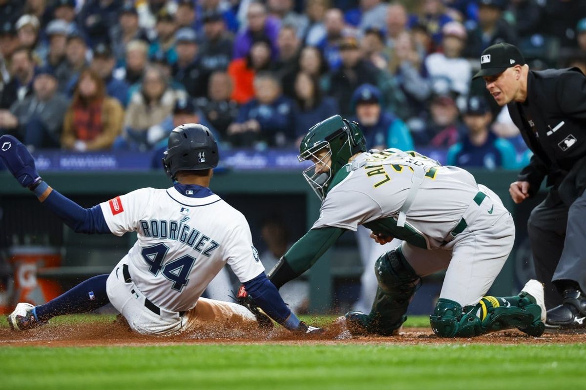 Mar 29, 2025; Seattle, Washington, USA; Athletics catcher Shea Langeliers (23) tags out Seattle Mariners center fielder Julio Rodríguez (44) on a fielders choice during the third inning at T-Mobile Park. Mandatory Credit: Joe Nicholson-Imagn Images