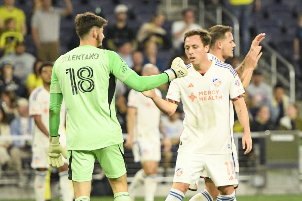 Mar 29, 2025; Nashville, Tennessee, USA;  FC Cincinnati forward Corey Baird (11) congratulates goalkeeper Roman Celentano (18) on the win against the Nashville SC during the second half at Geodis Park. Mandatory Credit: Steve Roberts-Imagn Images