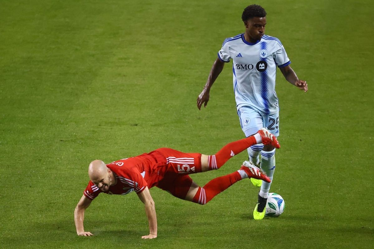 Mar 29, 2025; Chicago, Illinois, USA; Chicago Fire FC defender Andrew Gutman (15) kicks the ball against CF Montreal defender Dante Sealy (25) during the second half at Soldier Field. Mandatory Credit: Mike Dinovo-Imagn Images