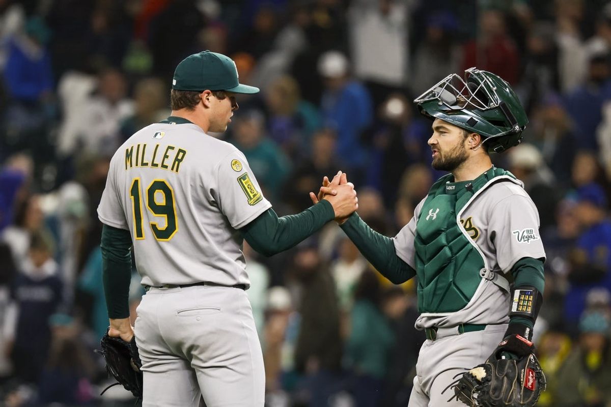 Mar 29, 2025; Seattle, Washington, USA; Athletics relief pitcher Mason Miller (19) shakes hands with catcher Shea Langeliers (23) following a strike out against the Seattle Mariners to end the ninth inning at T-Mobile Park. Mandatory Credit: Joe Nicholson-Imagn Images