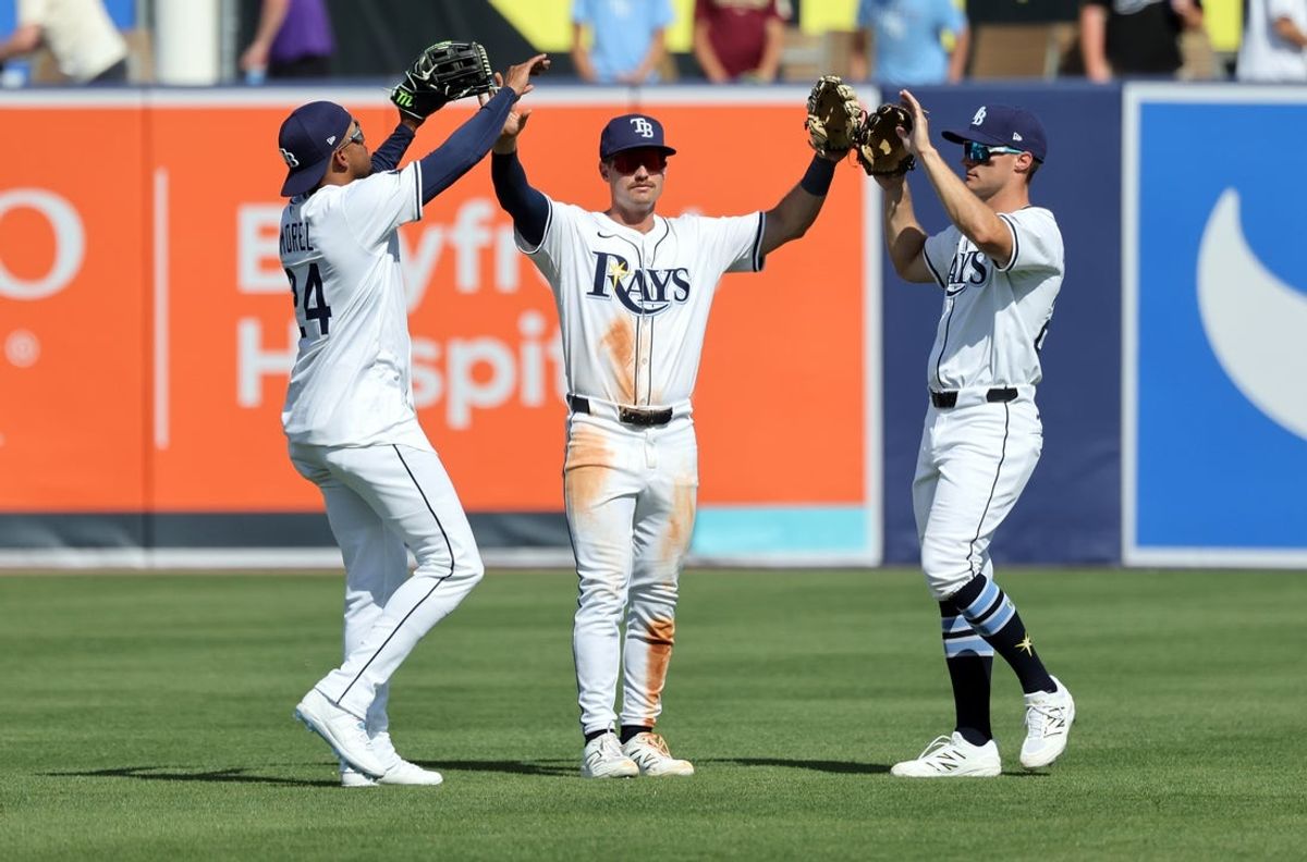 Mar 30, 2025; Tampa, Florida, USA; Tampa Bay Rays left fielder Christopher Morel (24), outfielder Jonny DeLuca (21) and right fielder Jake Magnum (28) celebrate after they beat the Colorado Rockies at George M. Steinbrenner Field. Mandatory Credit: Kim Klement Neitzel-Imagn Images