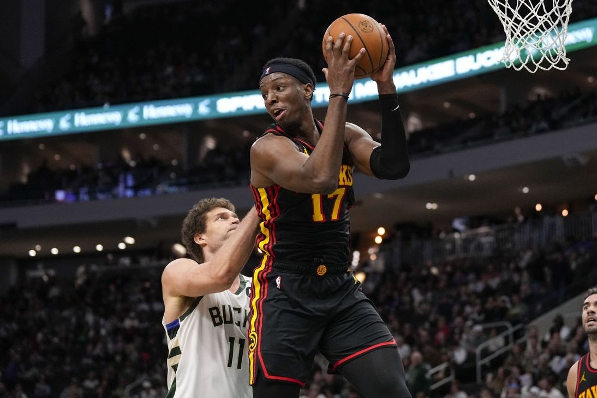 Mar 30, 2025; Milwaukee, Wisconsin, USA;  Atlanta Hawks center Onyeka Okongwu (17) grabs a rebound in front of Milwaukee Bucks center Brook Lopez (11) during the second quarter at Fiserv Forum. Mandatory Credit: Jeff Hanisch-Imagn Images
