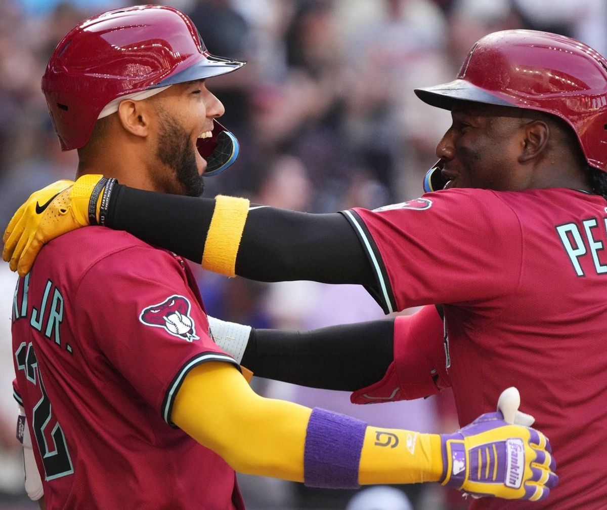 Arizona Diamondbacks Geraldo Perdomo (2) embraces teammate Lourdes Gurriel Jr. (12) after his 2-run home run against the Chicago Cubs at Chase Field in Phoenix on Sunday, March 30, 2025.
