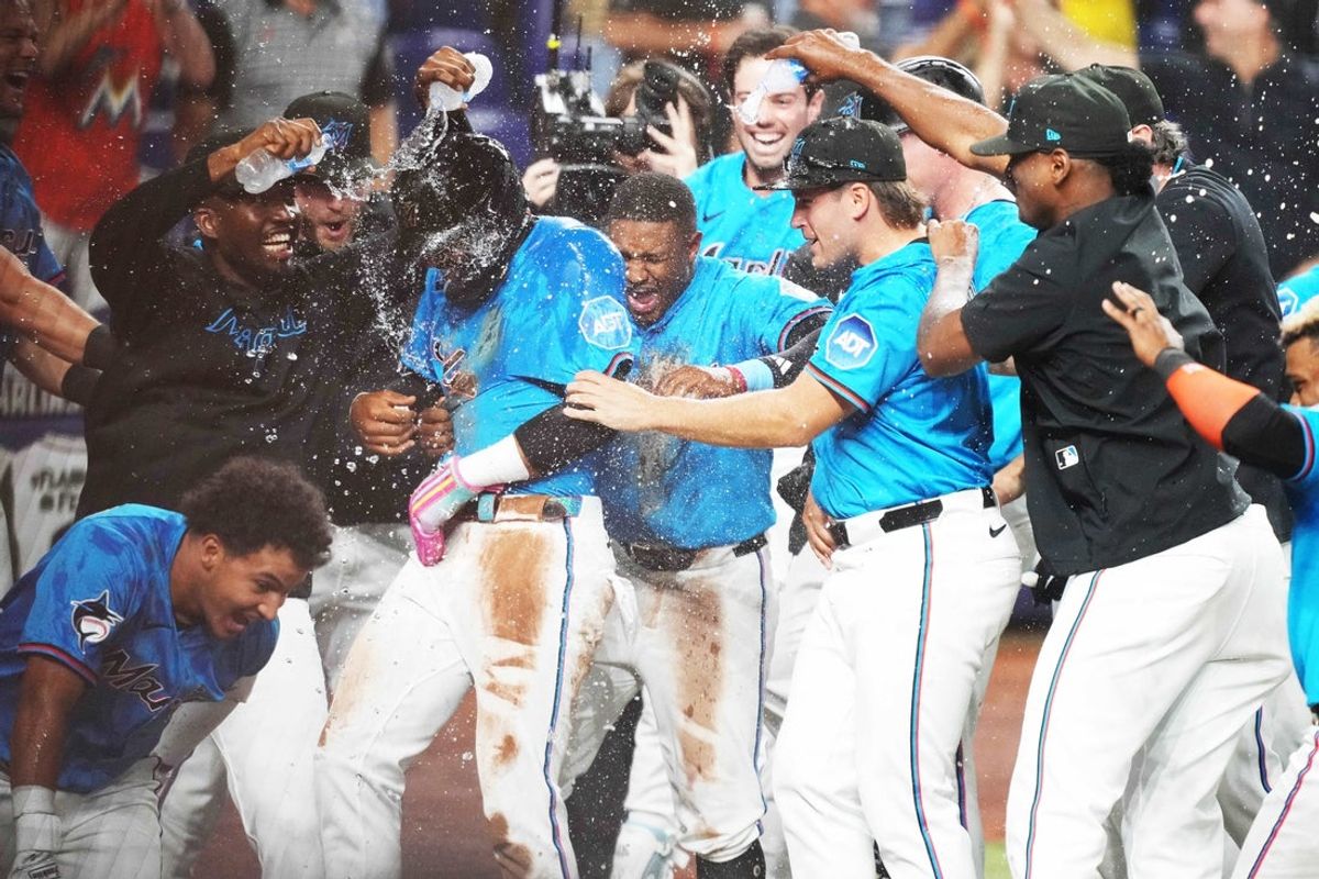 Mar 30, 2025; Miami, Florida, USA;  Miami Marlins designated hitter Derek Hill, left, celebrates scoring the winning run on a wild pitch against the Pittsburgh Pirates in the ninth inning at loanDepot Park. Mandatory Credit: Jim Rassol-Imagn Images