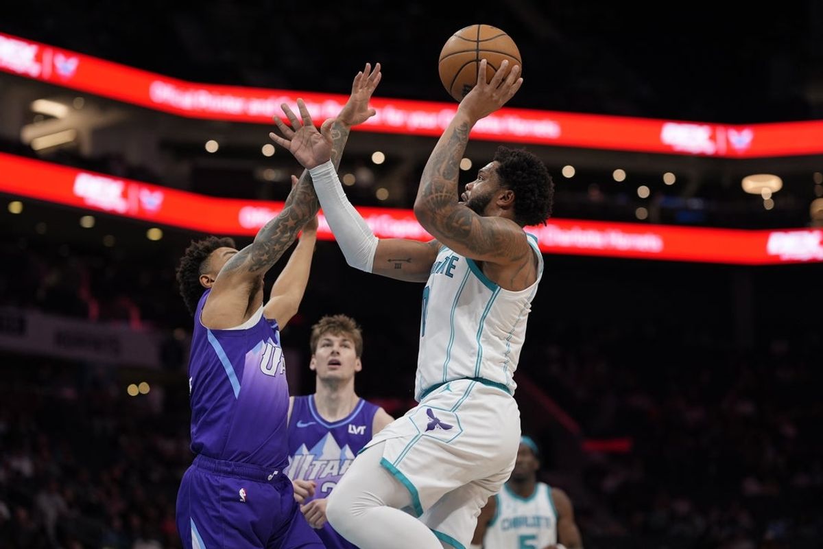 Mar 31, 2025; Charlotte, North Carolina, USA; Charlotte Hornets forward Miles Bridges (0) shoots the ball against Utah Jazz guard Keyonte George (3) during the second  quarter at Spectrum Center. Mandatory Credit: Jim Dedmon-Imagn Images