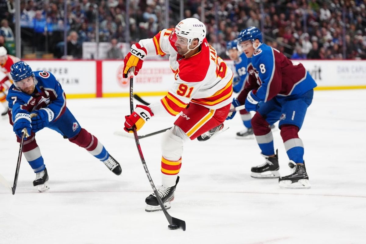 Mar 31, 2025; Denver, Colorado, USA; Calgary Flames center Nazem Kadri (91) shoots the puck in the first period against the Colorado Avalanche at Ball Arena. Mandatory Credit: Ron Chenoy-Imagn Images