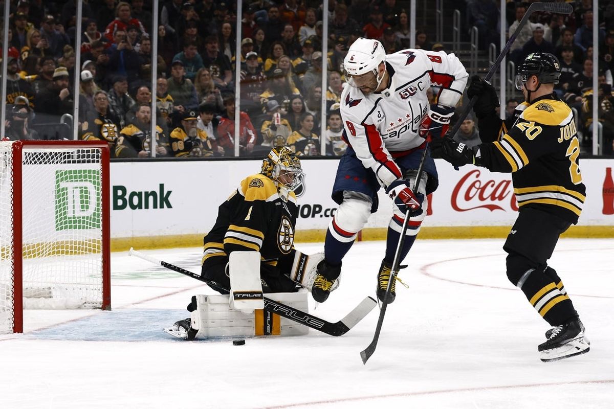 Apr 1, 2025; Boston, Massachusetts, USA; Washington Capitals left wing Alex Ovechkin (8) leaps over an incoming shot as Boston Bruins goaltender Jeremy Swayman (1) makes a pad save during the first period at TD Garden. Mandatory Credit: Winslow Townson-Imagn Images